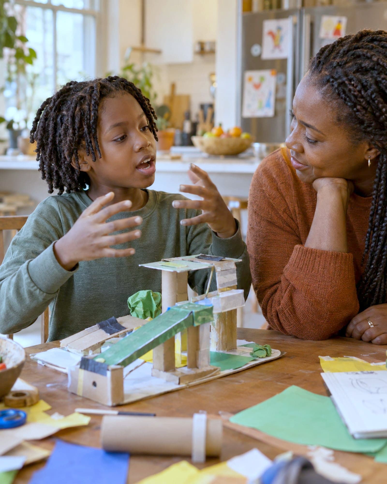 A child explaining the model they built to an adult who is listening.